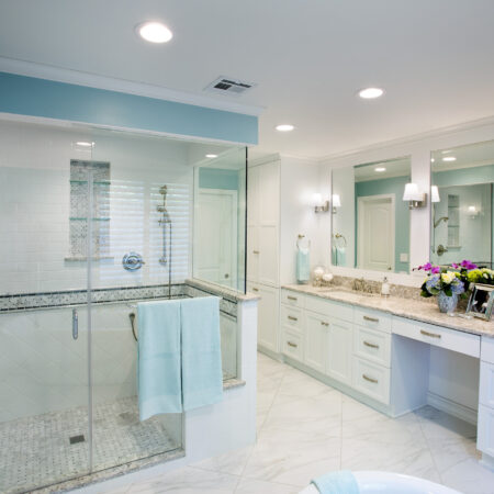Modern bathroom with glass-enclosed shower and double vanity in a bright, airy space.