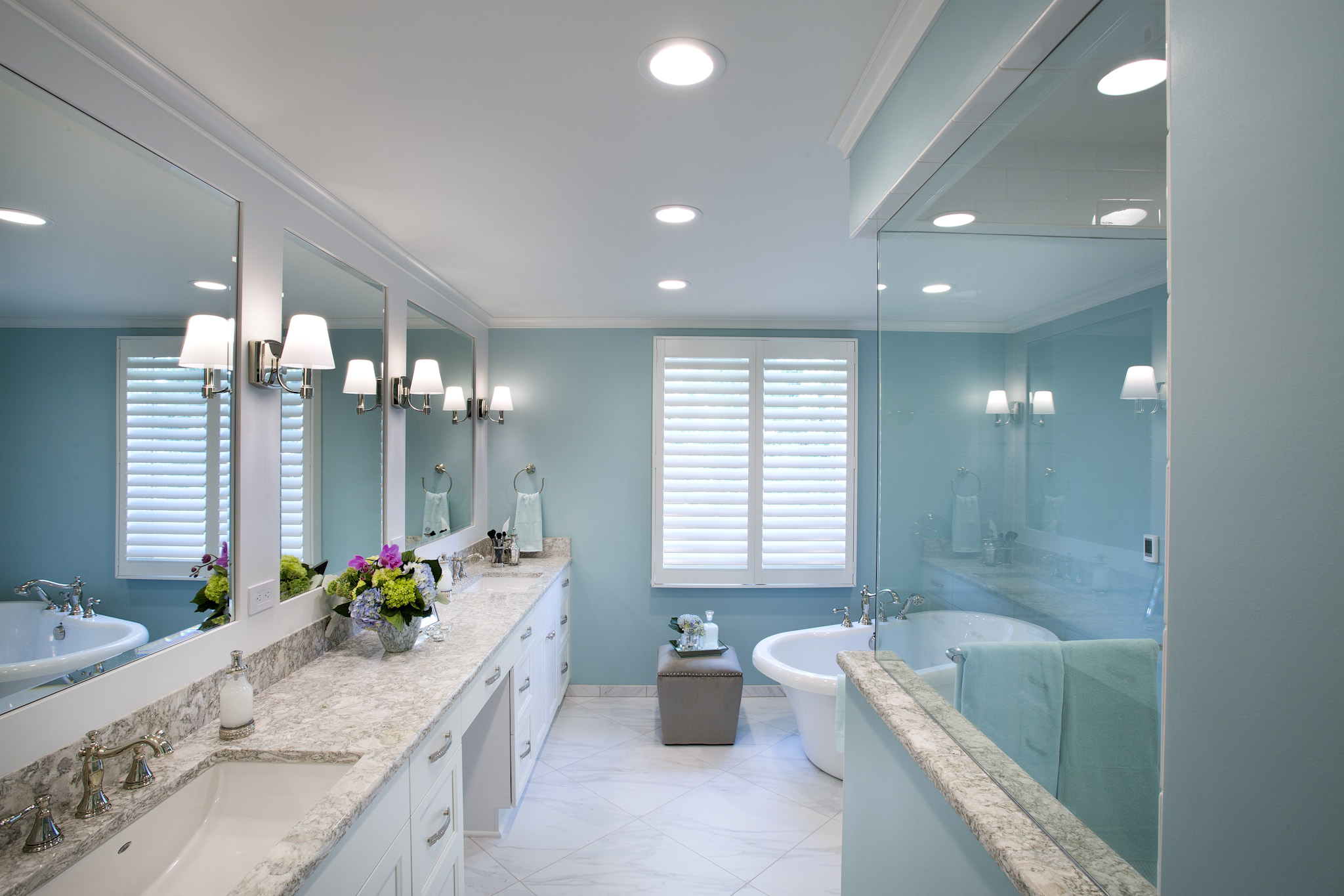 Elegant bathroom with light blue walls, white cabinetry, and modern fixtures in Wichita, Kansas.
