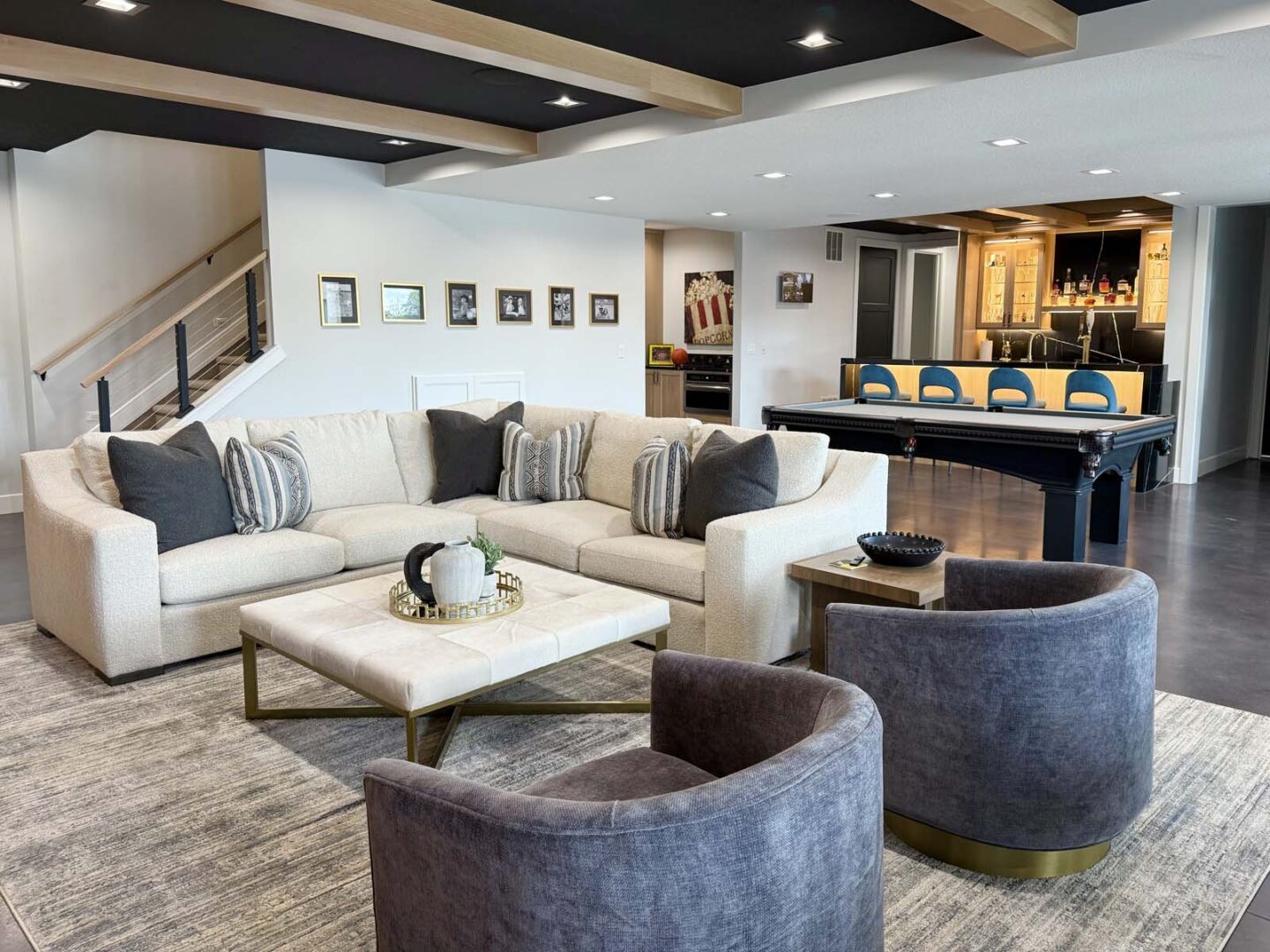 Spacious interior featuring a large white sectional sofa, cozy armchairs, and contemporary artwork o.