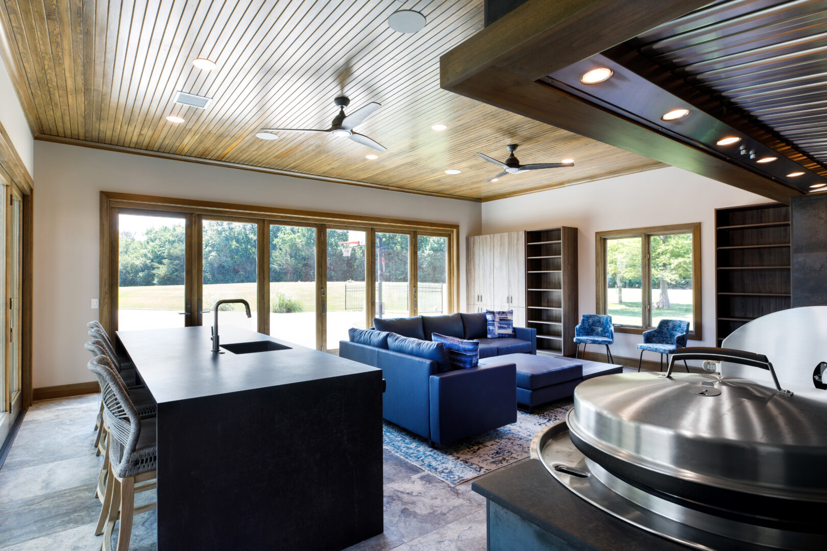 Bright, spacious living area with large windows, contemporary furniture, and a sleek kitchen island.