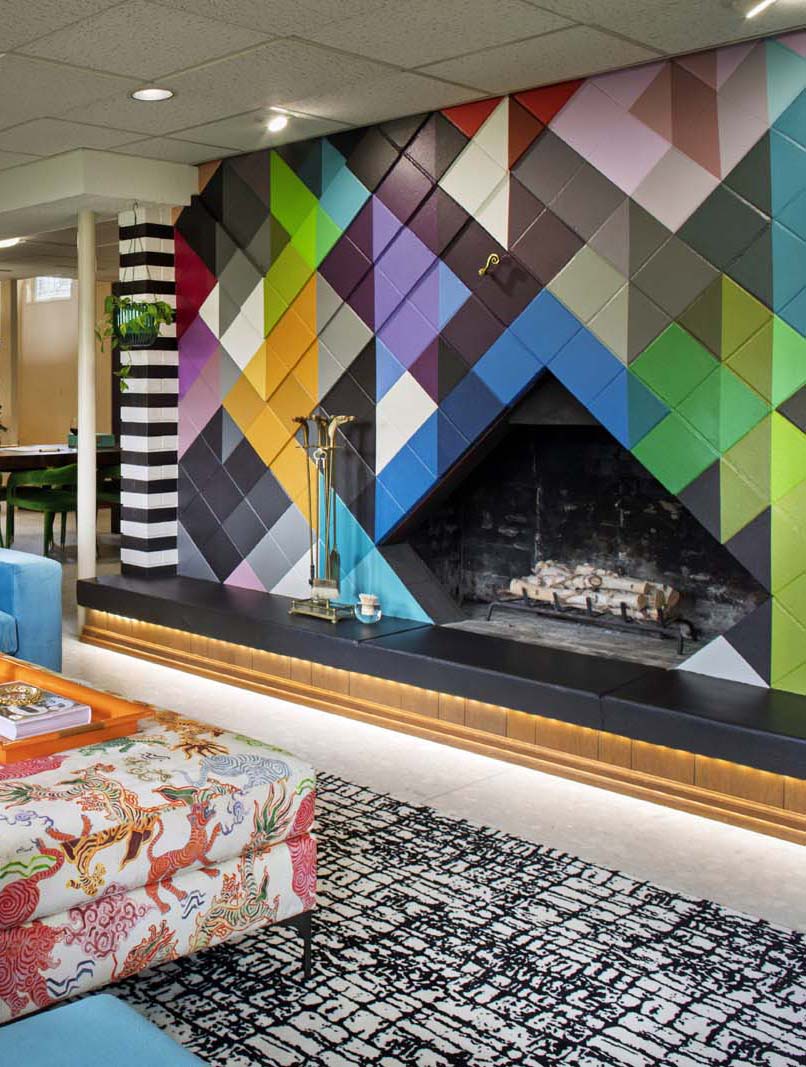 Colorful geometric mural wall design with fireplace in contemporary interior.