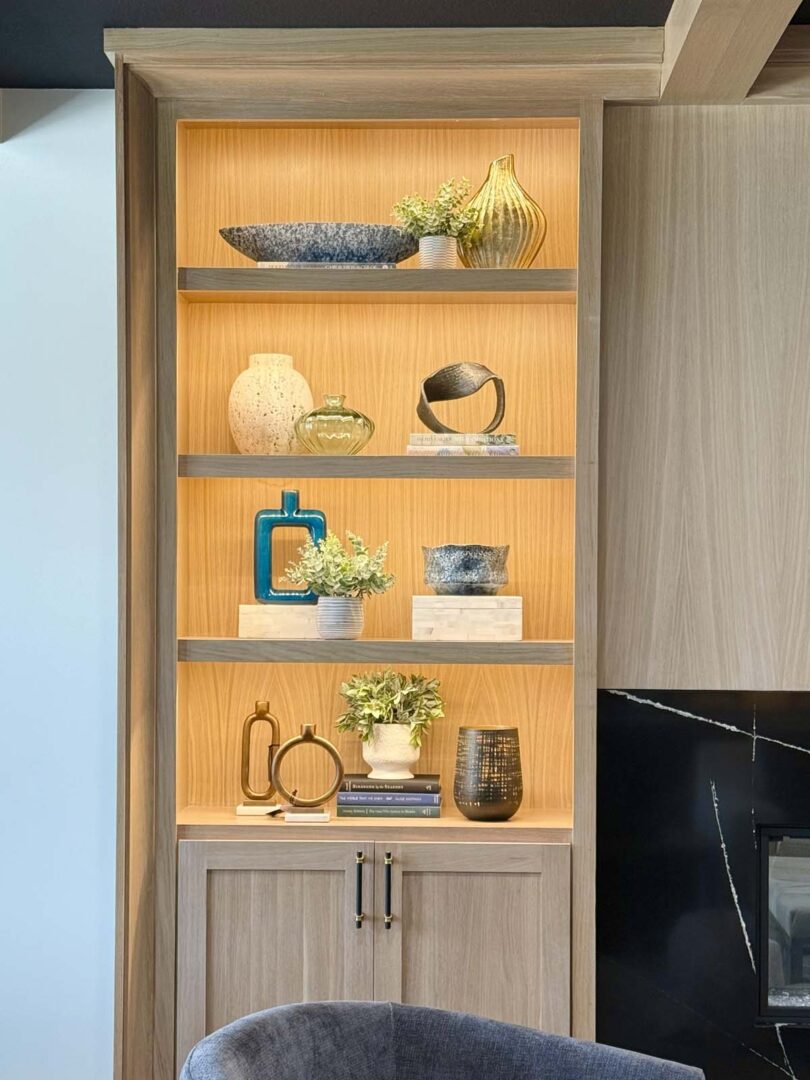 Elegant wooden display shelf with decorative vases, plants, and art pieces in a modern home.