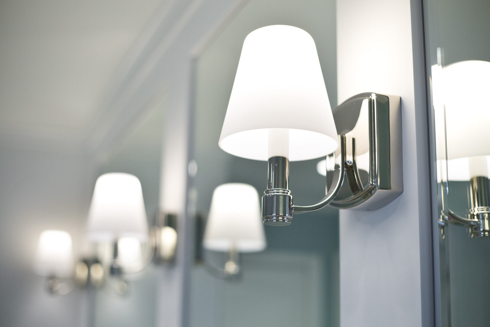 Wall sconce lighting fixture with white shade in interior decor.