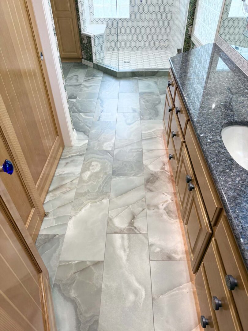 Elegant marble tile flooring with a polished finish in a contemporary bathroom setting.
