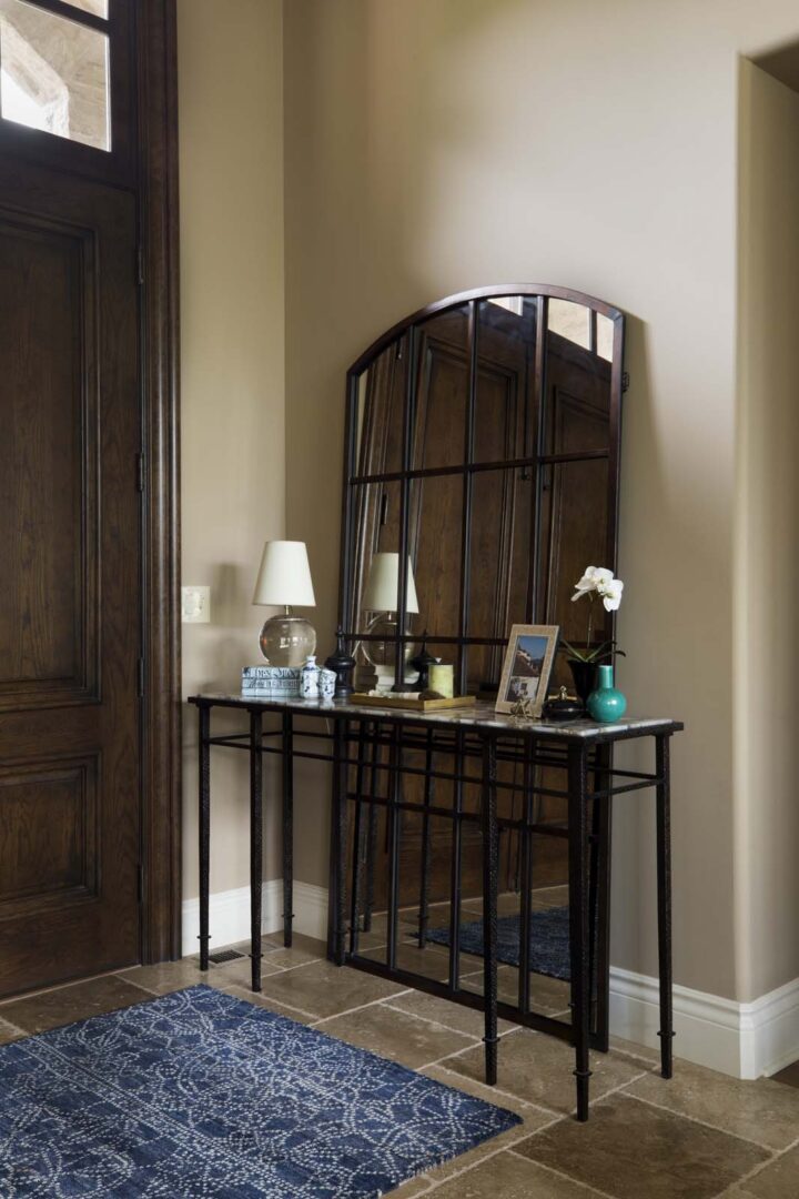 Stylish entryway with a large arched mirror, console table, and decorative accents in a home.