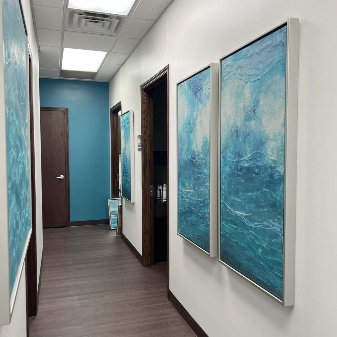 Blue abstract wall art paintings in a contemporary interior hallway.