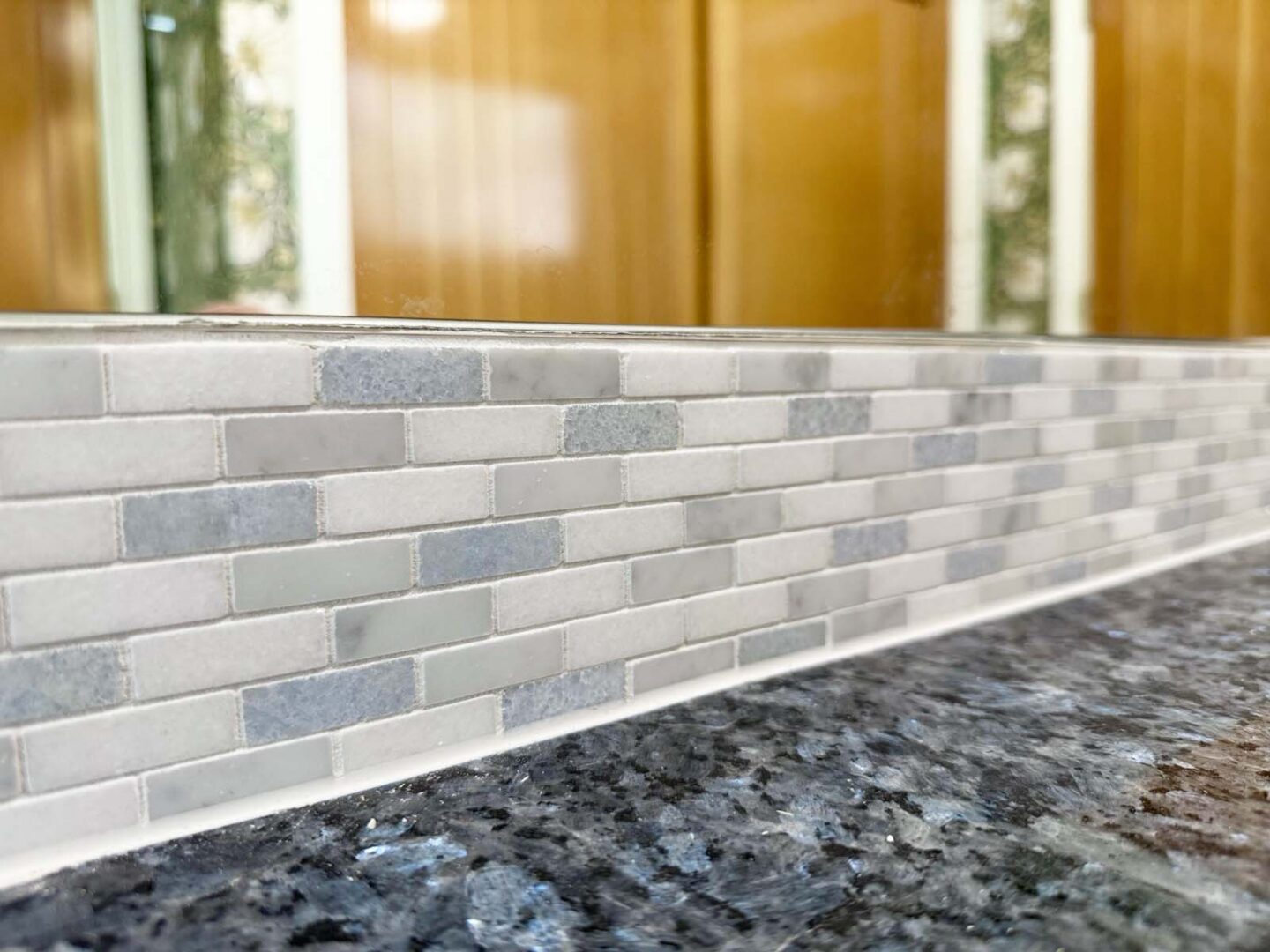 Modern kitchen backsplash featuring gray tiles and granite countertop in a contemporary kitchen.