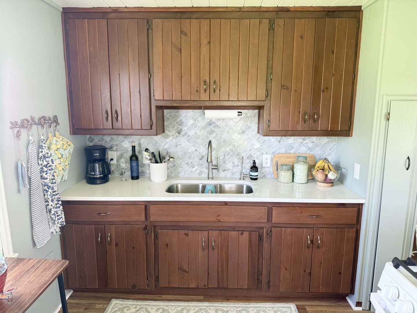 Kitchen featuring wooden cabinets, a stainless steel sink, and modern appliances in a bright, inviti.